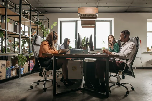A diverse call center team working on computers with headsets in a modern office setting. Designing translation agency service packages: seventeen shapes and their failure modes