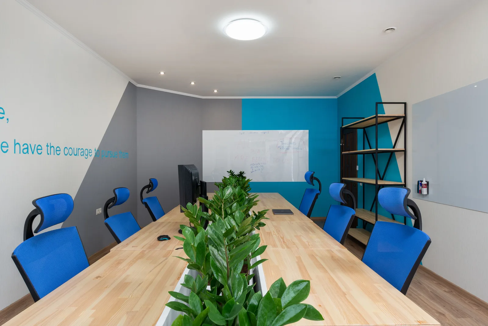 Armchairs at table with green plants placed in light conference room with inscription on wall and shelves in office building. Translation Agency Insurance in Texas: What You Need